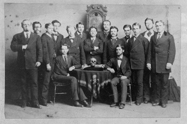 Skull & Bones society In this photo of Skull & Bones secret society members, the man at the far left of the photo is seen displaying the hidden hand sign. Exact date of photo unknown, appears to be around the mid-1800′s.